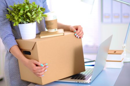 Happy team of businesspeople moving office, packing boxes, smiling.